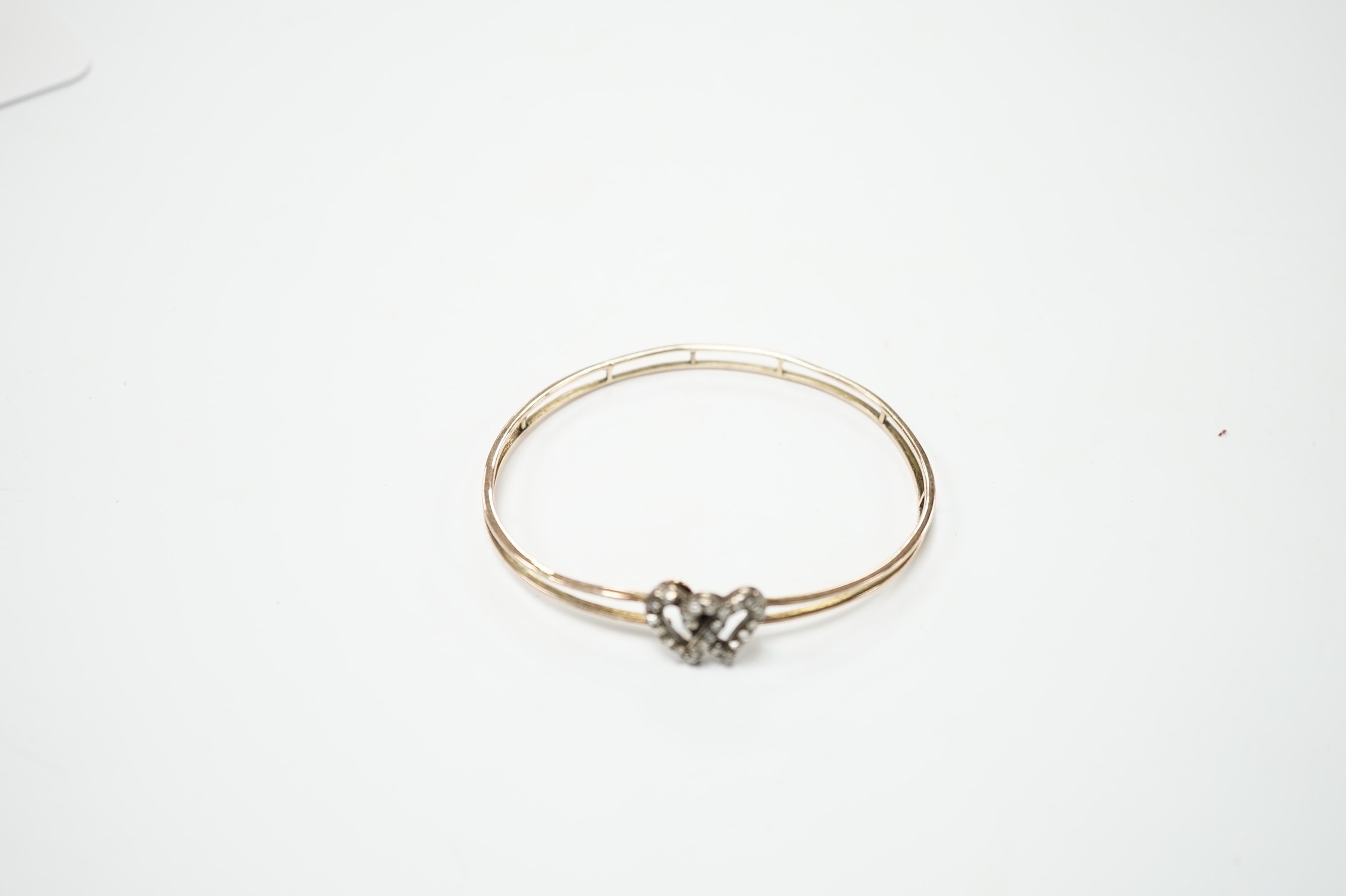 A late Victorian yellow metal and rose cut diamond set twin hearts bangle, gross weight 6.8 grams.